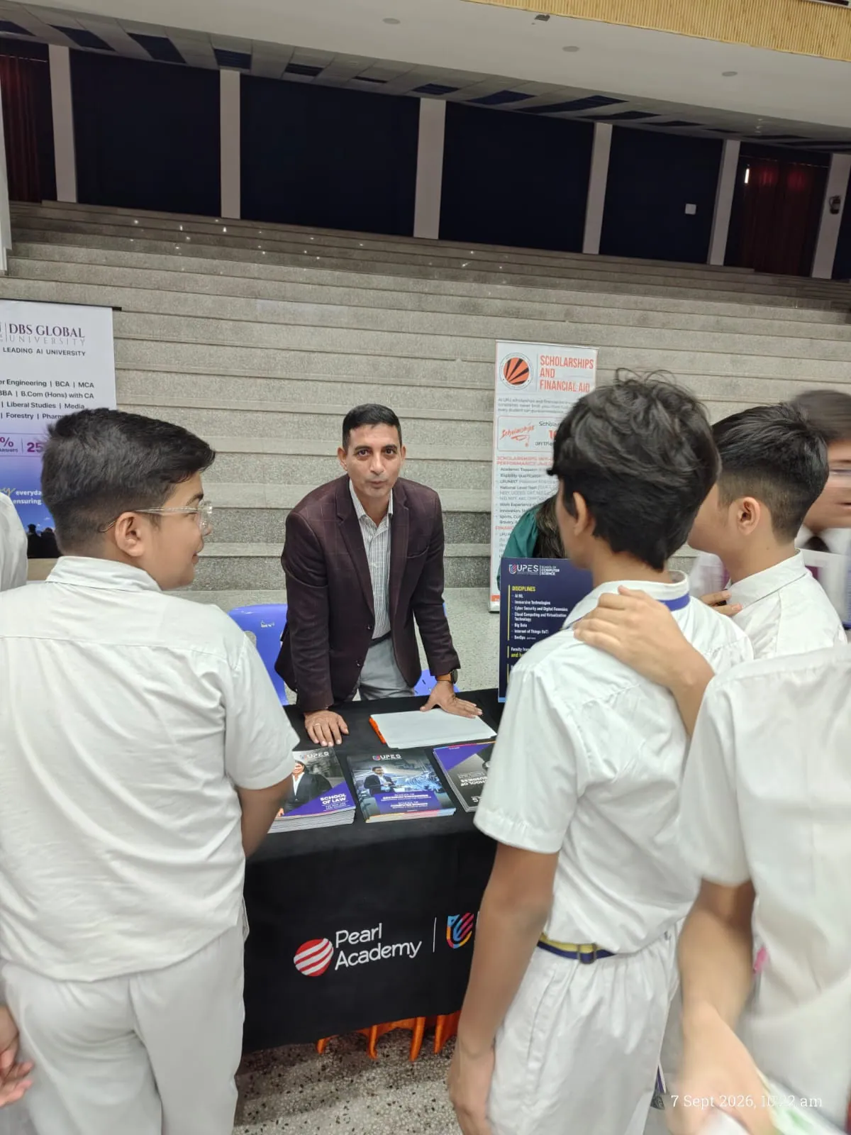 Mentor in blazer advising high school students on academic disciplines